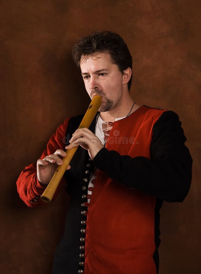 Man in a medieval suit plays a flute