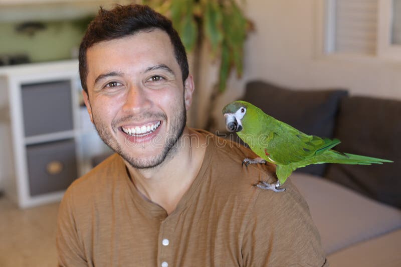 Man holding green dwarf macaw. Man holding green dwarf macaw.