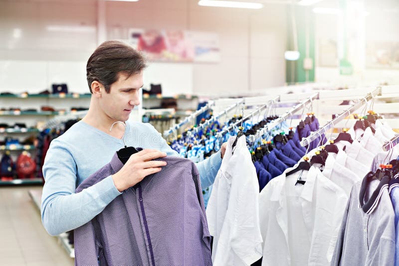 Man chooses shirt in shop stock foto. Image of winkelcentrum - 112370822