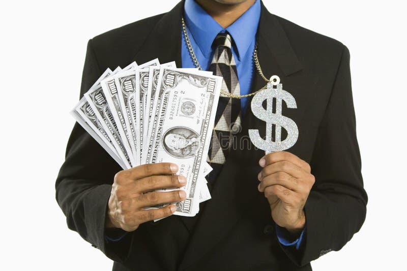 African American man in suit wearing necklace with money sign and holding cash. African American man in suit wearing necklace with money sign and holding cash.