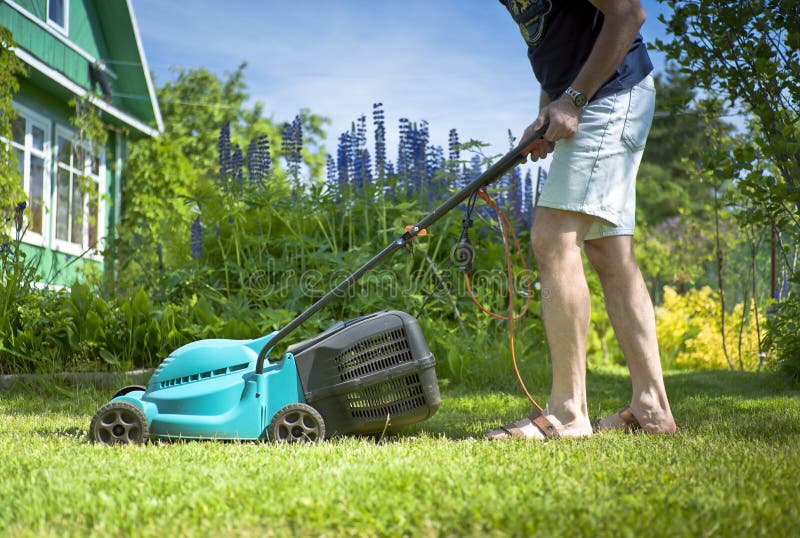 Man mowing the lawn in the yard royalty free stock photography