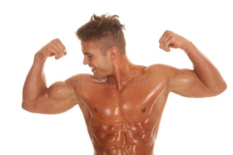 A man with sweat all over his body flexing. A man with sweat all over his body flexing.