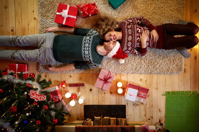 Man och kvinna som ligger på golvet för jul, bästa sikt arkivfoto Man och kvinna som ligger på golvet för jul, bästa sikt arkivfoto