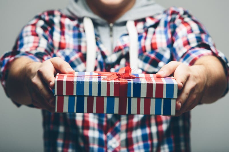 Man Offering Stripe Gift Box with Red Ribbon Stock Photo Image of