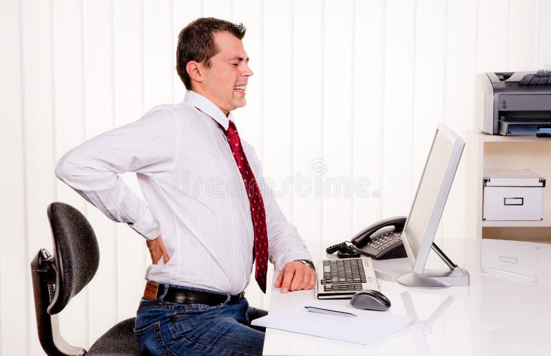 Junger Mann im Büro mit computer-und Rückenschmerzen.