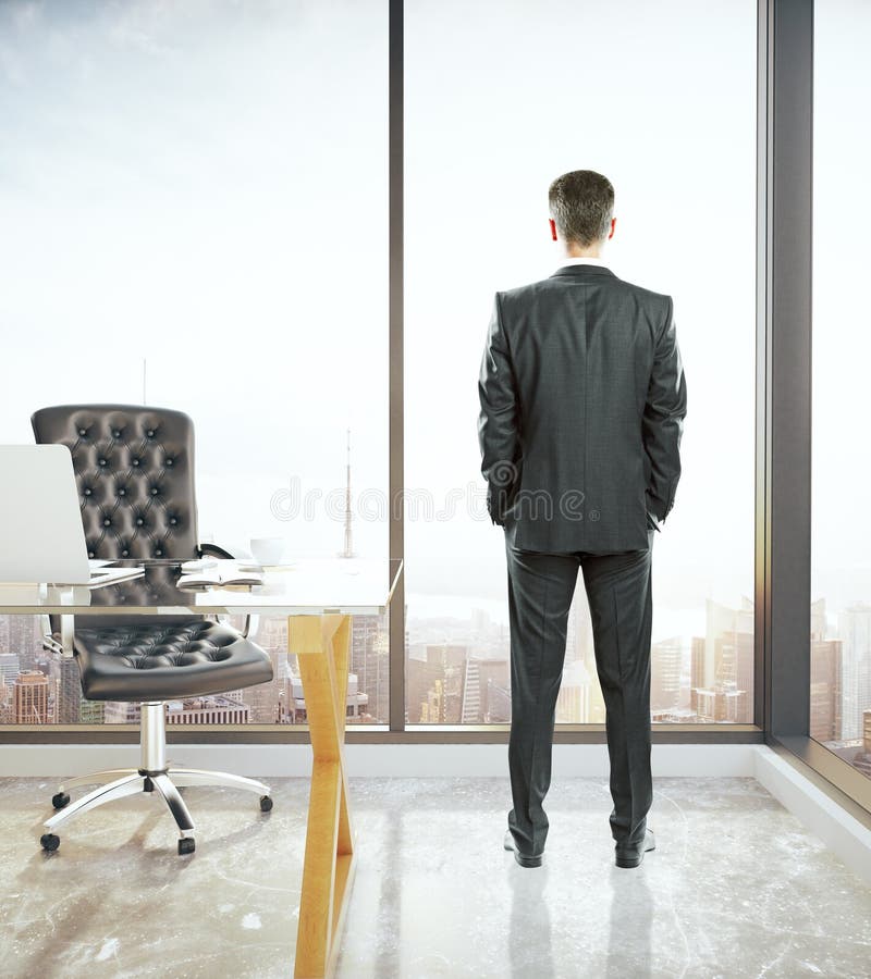 Man in office looking out window