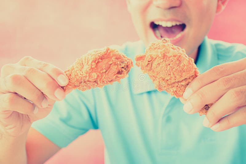 A man with opening mouth about to eat deep fried chicken legs royalty free stock photography A man with opening mouth about to eat deep fried chicken legs royalty free stock photography