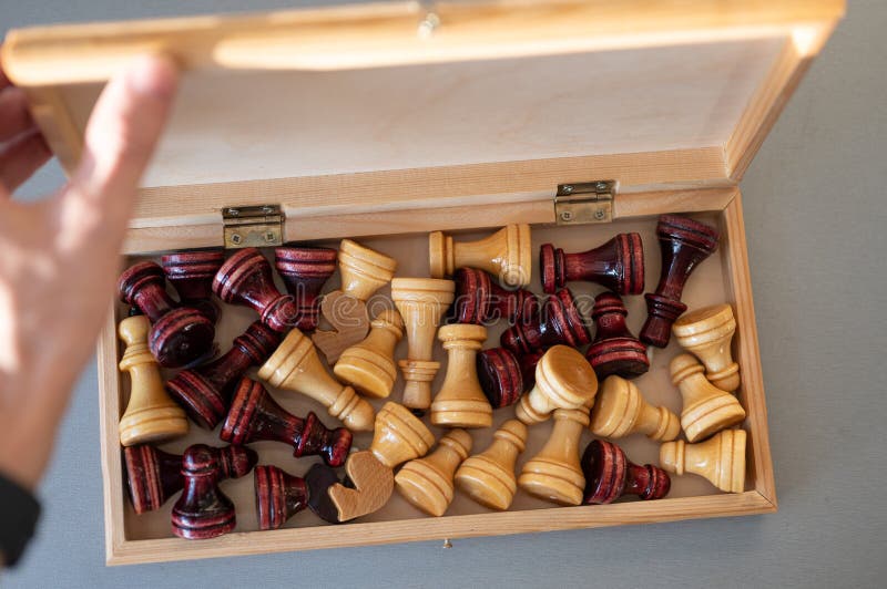 Man opening wooden chessboard with chess pieces