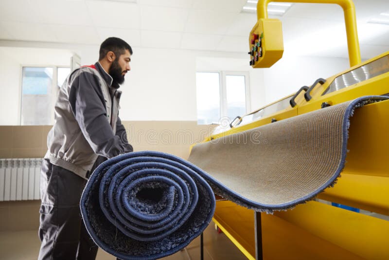 Man Operating Carpet Automatic Cleaning Machine in Professional Laundry