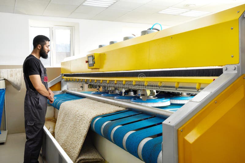 Man Operating Carpet Automatic Washing Machine in Professional Laundry