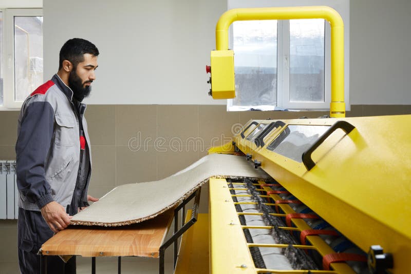 Man Operating Carpet Automatic Washing Machine in Professional Laundry