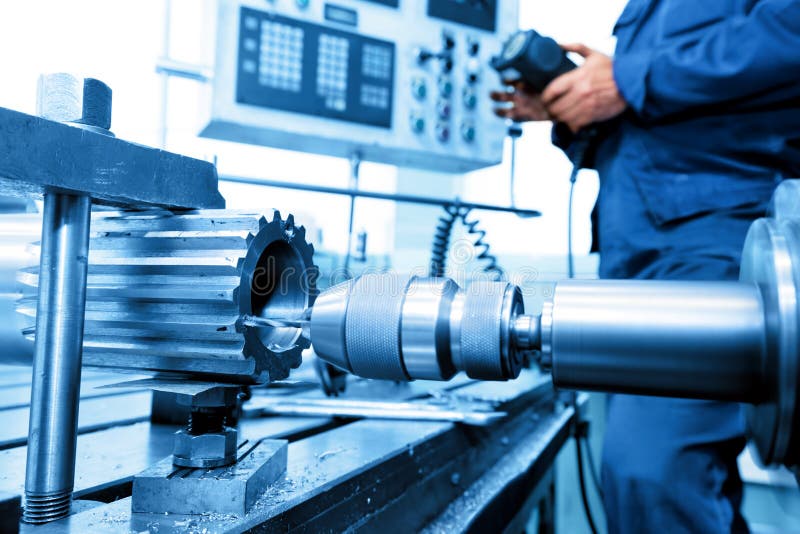 Uomo di funzionamento di CNC di foratura e barenatura macchina in officina.