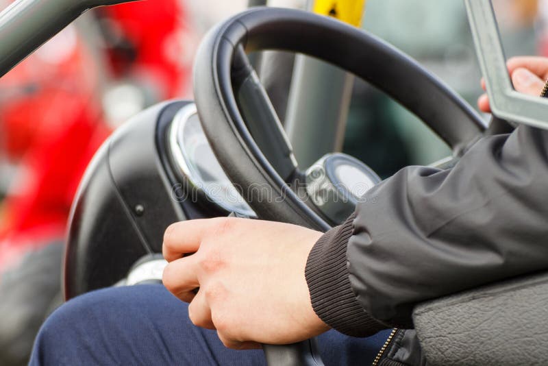 Man Operating Control Panel and Steering Wheel in Agricultural or Industrial Machine Stock Photo