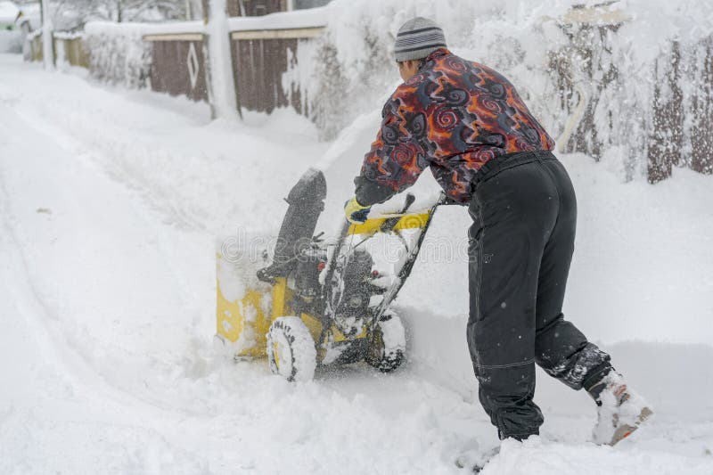 Man Operating Snow Blower To Remove Snow on Driveway. Man Using a