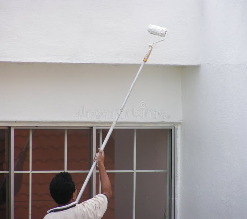 L'uomo dipingere una parete di casa utilizzando un rullo o pennello.