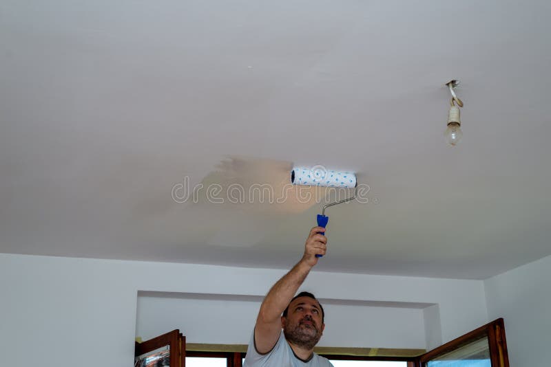Man painting a ceiling stock image. Image of apartment 206412139