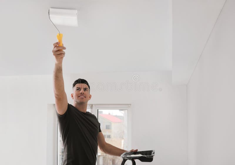Man Painting Ceiling with Roller in Room Stock Image Image of brush