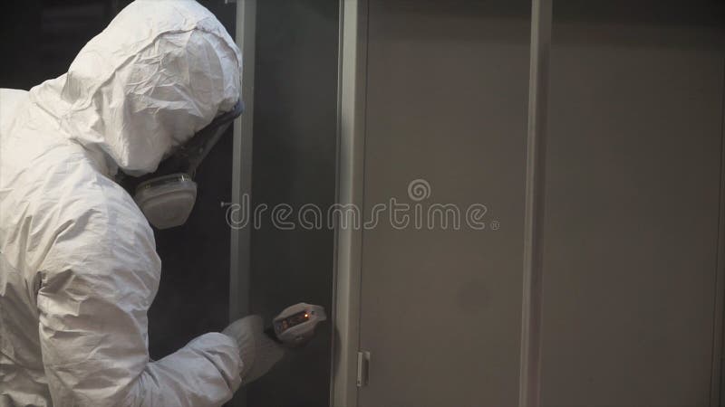 Man painting with spray paint gun in workshop. Clip. Industrial metal coating. Man in protective suit, wearing a gas stock photography Man painting with spray paint gun in workshop. Clip. Industrial metal coating. Man in protective suit, wearing a gas stock photography