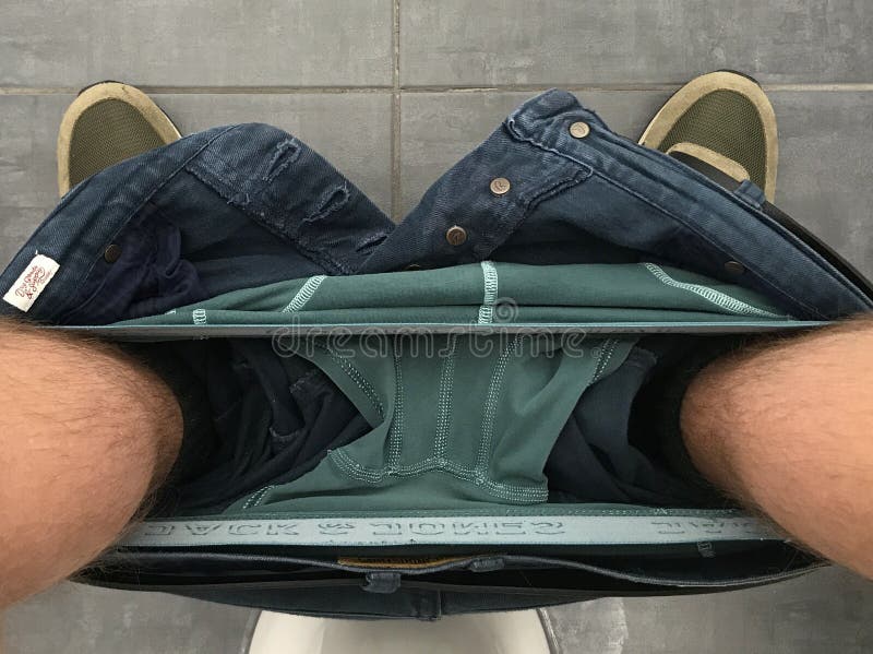 Man, with His Underwear Down, Sitting on the Toilet, with a Roll of