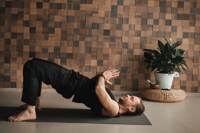 A Man Performing Gymnastic Exercises on a Yoga Mat at Home Stock Image