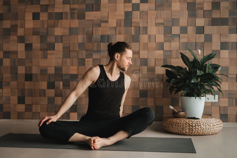 A Man Performing Gymnastic Exercises on a Yoga Mat at Home Stock Image