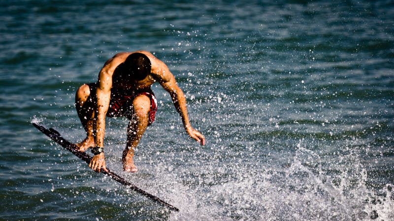 Man performs stunts on his surfboard royalty free stock image Man performs stunts on his surfboard royalty free stock image