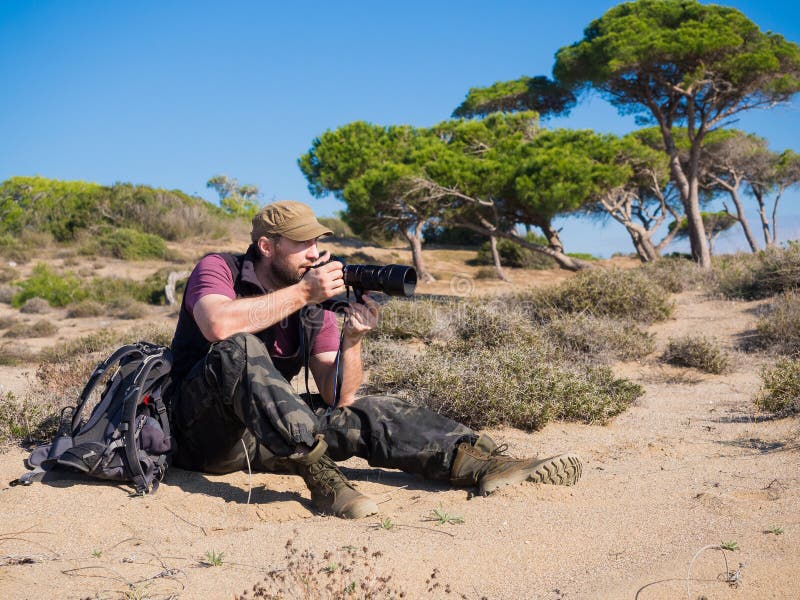 Man photographer in savanna taking a picture of a wild life of an animals. royalty free stock images Man photographer in savanna taking a picture of a wild life of an animals. royalty free stock images