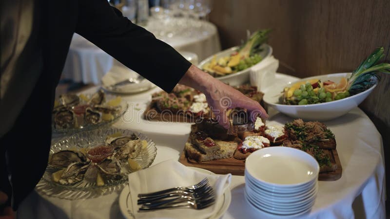 A man picks up a sandwich from the buffet at an event. stock video
