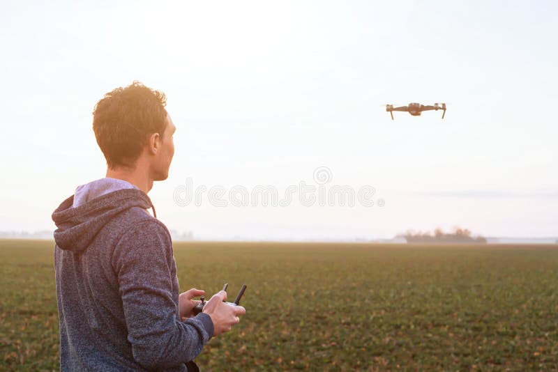 Man piloting drone at sunset