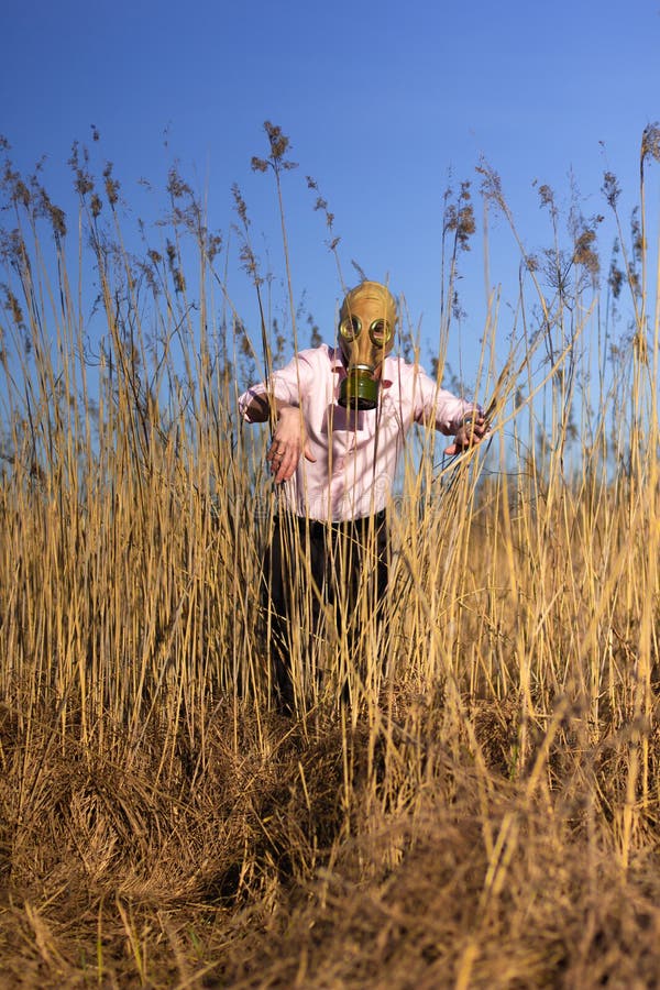 Man In Pink Shirt And Gas Mask Sneaking Up In Reeds Field Stock Image ...