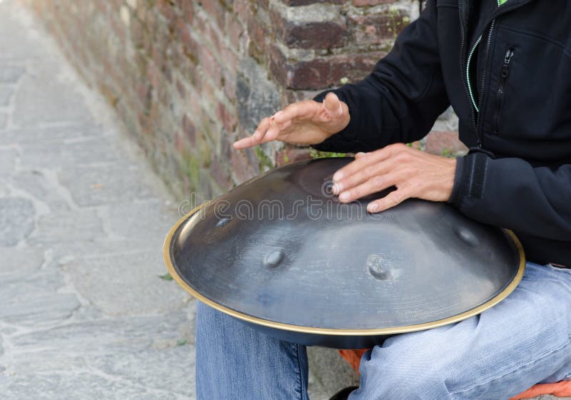 Man play instrument made of metal and called hang duo toned. Metal steel drum stock images, royalty-free photos and pictures