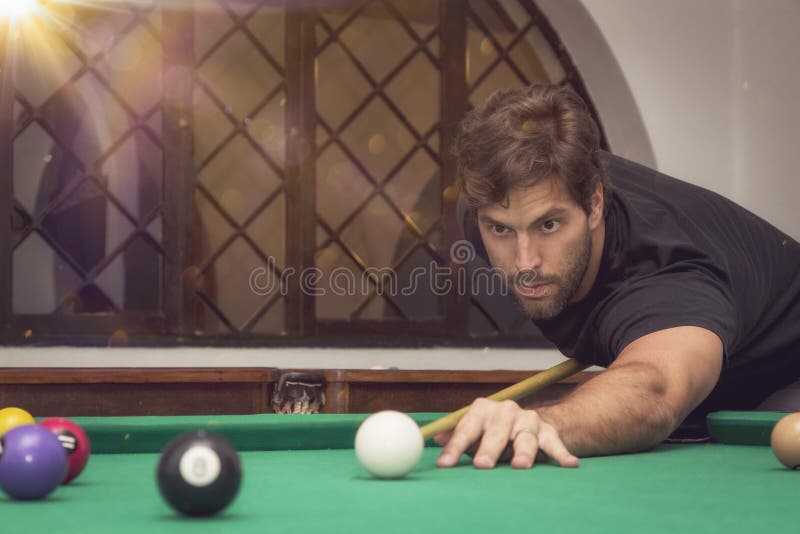 Man Playing Billiards in a Pool Table. Stock Photo Image of green