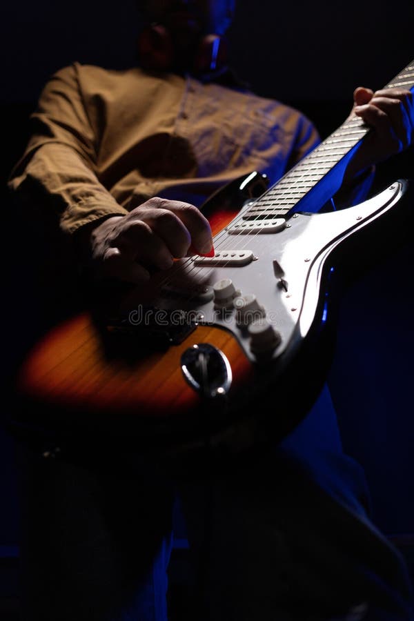 Man Playing Electric Guitar. Musician in Studio Holding Electric Guitar