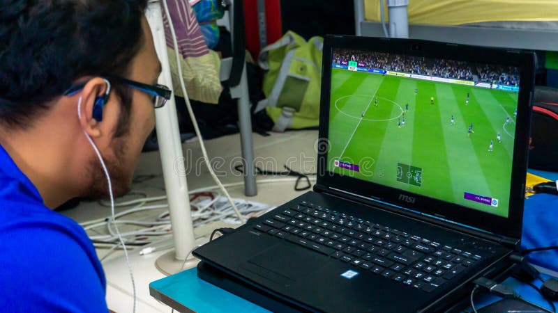 A man playing Fifa 19 on gaming laptop using a console