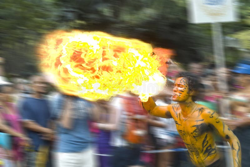 Man, flame blower is playing with fire during the street's show. Motion blurred background. Carnival in Seychelles. March, 2012. The left side of picture is free for your text. Seychelles stock images, royalty-free photos and pictures