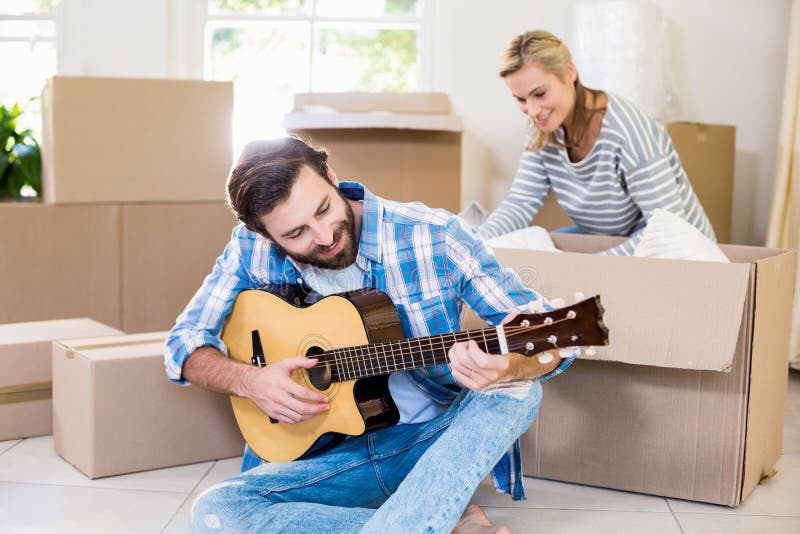 Teenage Girl Playing Guitar While Sitting On Floor