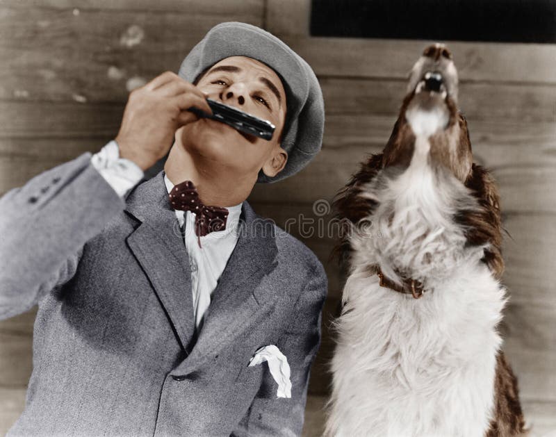 Man playing harmonica with howling dog (All persons depicted are no longer living and no estate exists. Supplier grants that there will be no model release issues.)