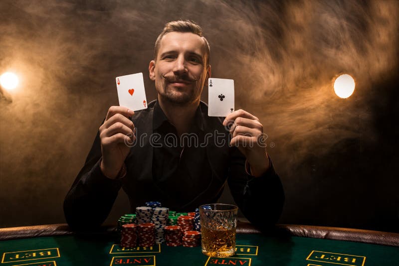 Man is playing poker with a cigar and a whiskey, a man show two cards in the hand, winning all the chips on the table stock photography Man is playing poker with a cigar and a whiskey, a man show two cards in the hand, winning all the chips on the table stock photography