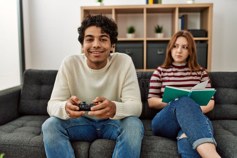 Man disappointed while playing video game with girlfriend at home stock  photo