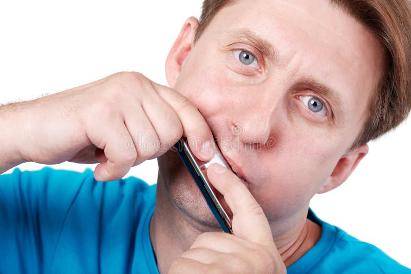 Man in blue t-shirt plays mouth harmonica. Man in blue t-shirt plays mouth harmonica