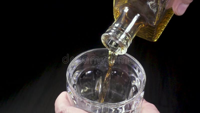 Man pouring whiskey into a glass from a carafe