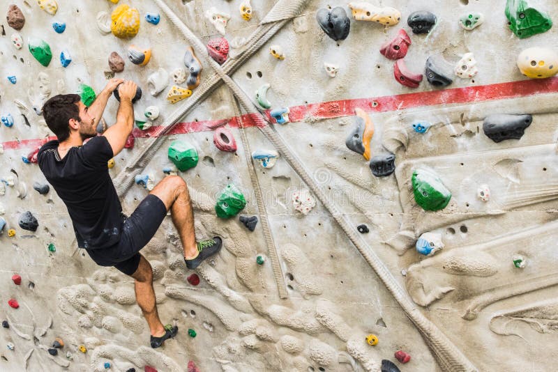Man Practicing Rock Climbing on Artificial Wall Indoors. Active