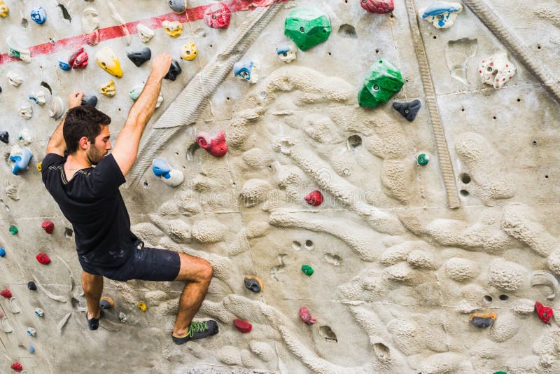 Man Practicing Rock Climbing on Artificial Wall Indoors. Active