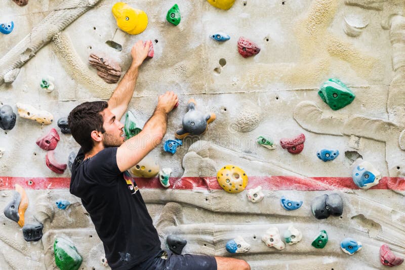 Man Practicing Rock Climbing on Artificial Wall Indoors. Active