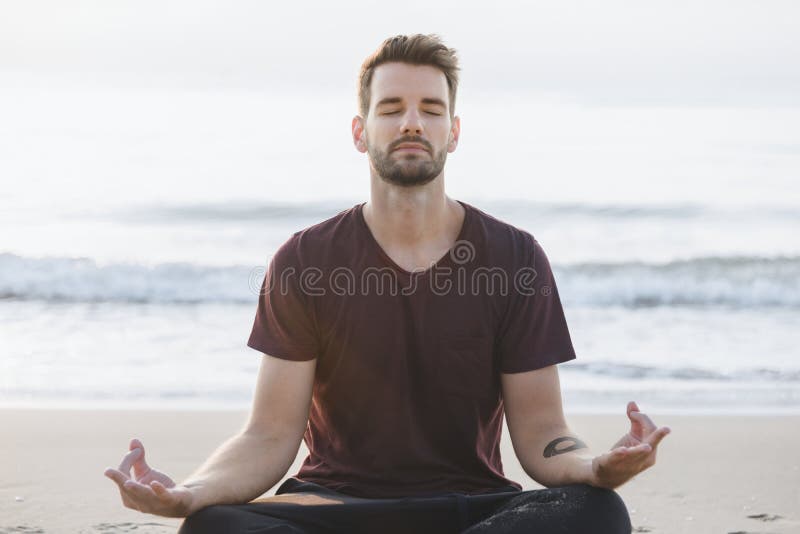 A man practicing yoga at the beach stock photography