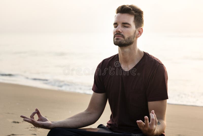 Man practicing yoga on the beach royalty free stock image