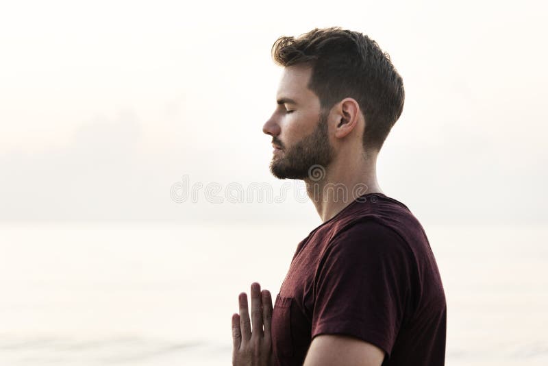 Man practicing yoga on the beach stock photography