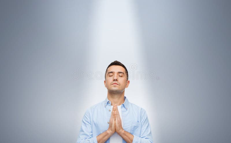 Man Praying Under Ray Of Ligh