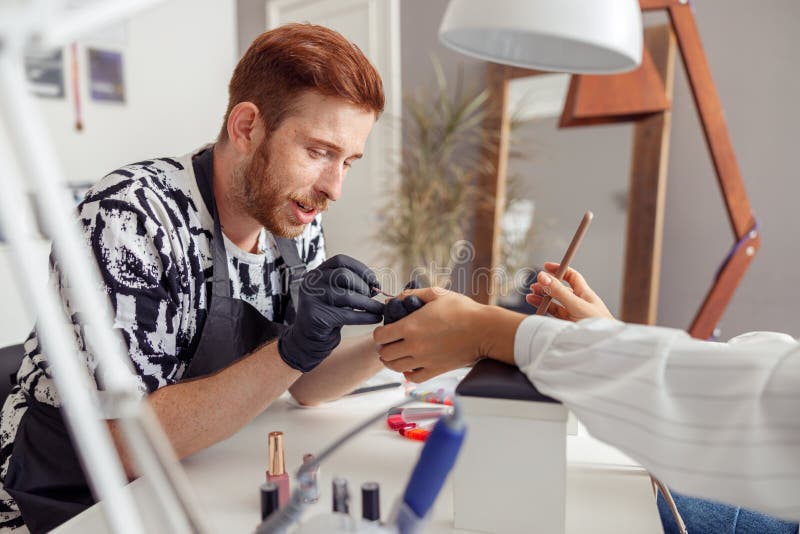 Skillful Nail Master Working with Client in Beauty Salon Stock Photo