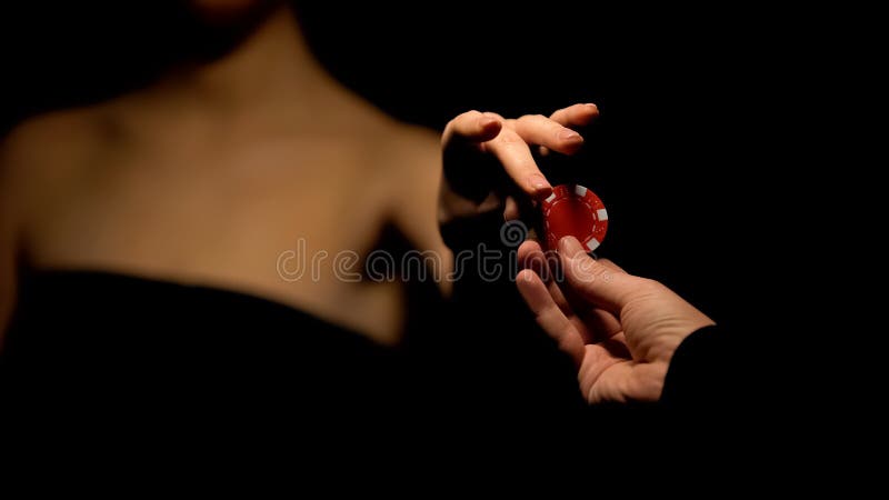 Man proposing woman poker chip, inviting for game, isolated on black background stock photo Man proposing woman poker chip, inviting for game, isolated on black background stock photo